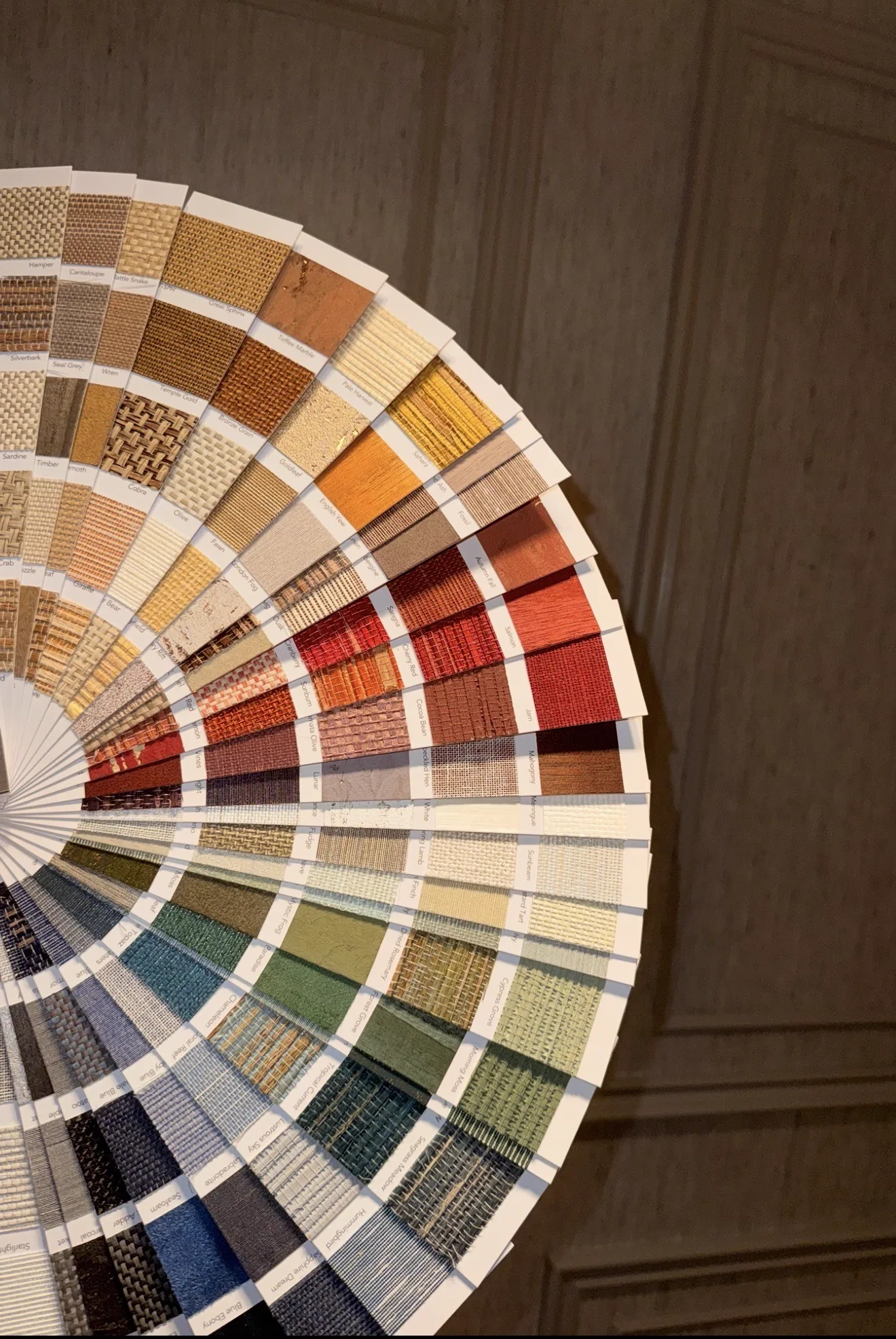 The John Mark Naturals Top 160 fan book opened out to show a wide spectrum of natural wallcovering swatches, from pale weaves to deep reds, greens and blues